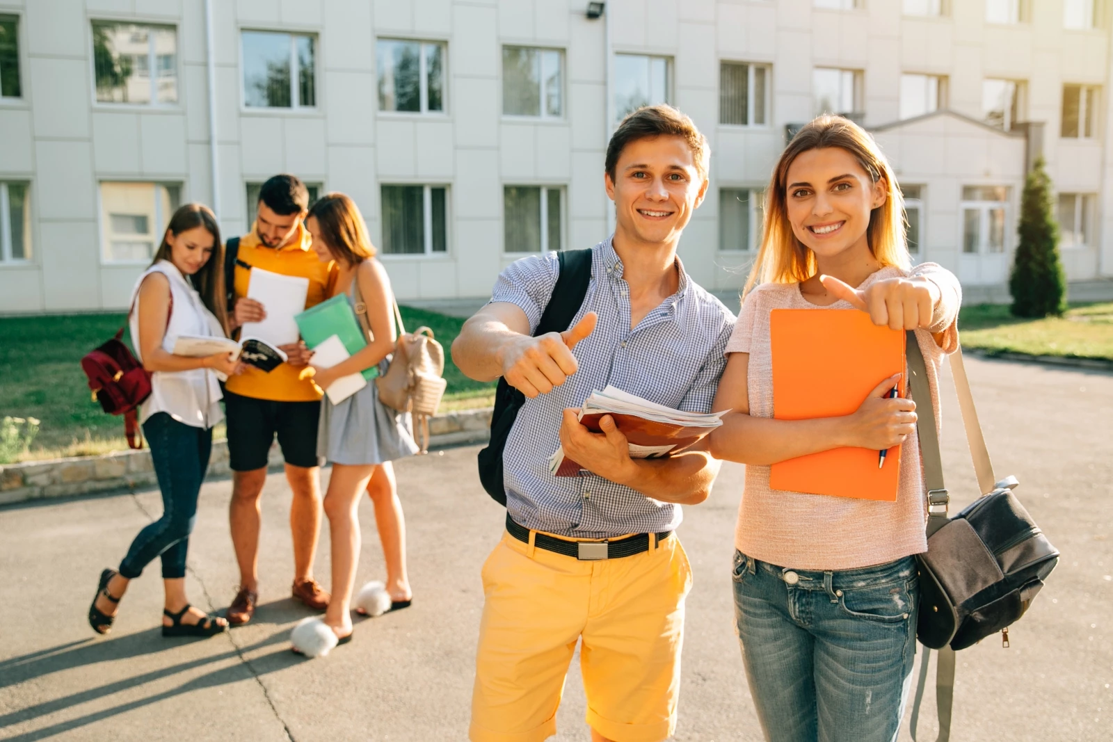 happy-two-young-students-with-note-books-backpacks-smiling-showing-thumb-up_sm.webp